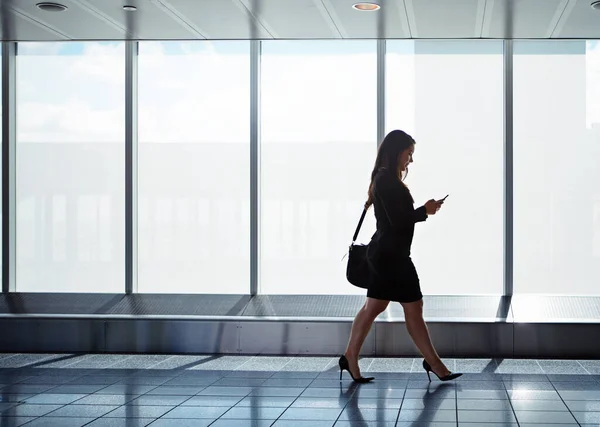 Håller Kontakten Språng Affärskvinna Som Promenerar Längs Flygplatskorridor Med Mobiltelefon — Stockfoto