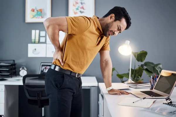 stock image Night, back pain and business man with stress at office desk in a modern workplace. Professional asian male person with health, body ache or burnout problem while tired, injured and working late.
