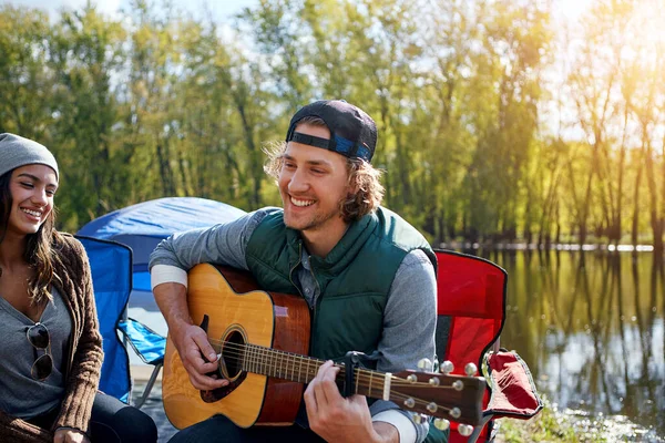 젊은이가 캠핑중에 친구에게 기타로 노래를 있습니다 — 스톡 사진