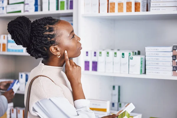 Black woman, patient and thinking for healthcare drugs, medication decision for pain relief on pharmacy shelf. Thoughtful African female customer looking at pharmaceutical products for self diagnosis.