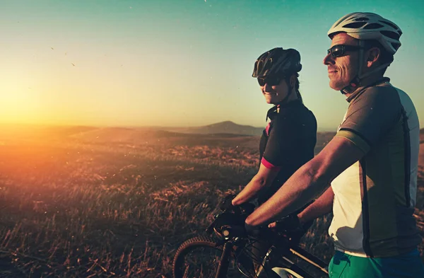 Stock image Come for the exercise, stay for the view. a pair of adventurous mountain bikers out on a trail on a sunny day