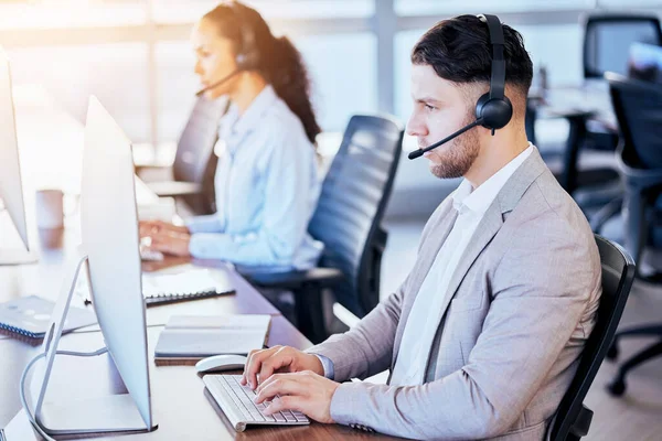 Call center, computer and typing man in office for customer service, technical support and help desk. Telemarketing, contact us and communication with employee for sales advice, operator or crm focus.