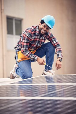 Tornavida, mutlu adam portresi ve çatı katındaki fotovoltaik elektrik hücresinin güneş paneli kurulumu. Sürdürülebilir, eko yenilenebilir enerji ve sürdürülebilirlik plaka araçları olan erkek tamirci.