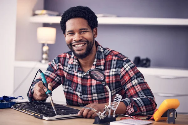 Black man, technician fixing electronics and tablet hardware, soldering iron tools and tech repair. Maintenance, magnifying glass and electrical fix with happy male in portrait working on device.