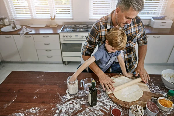 Add some more flour...a father and his son making pizza at home