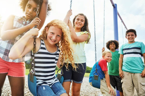 誰が最高のスイングすることができますしてください 公園で遊ぶ若い子供たちのグループの肖像画 — ストック写真