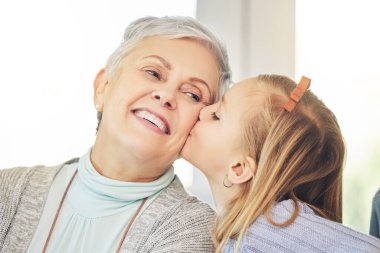 Öpücük, ilgi ve çocuk bir evde sevgi, mutluluk ve aile desteği olarak büyükanneyi yanağından öpüyor. Gülümse, bağ kur ve son sınıftaki bir kadına ya da büyükanneye minnettarlığını göster..
