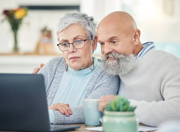 stock image Laptop, senior couple and video call in home, internet browsing or social network in house. Computer, retirement and serious man and woman in virtual conference, online chat or communication together.