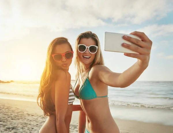 stock image These are lasting memories. two friends taking selfies while hanging out at the beach