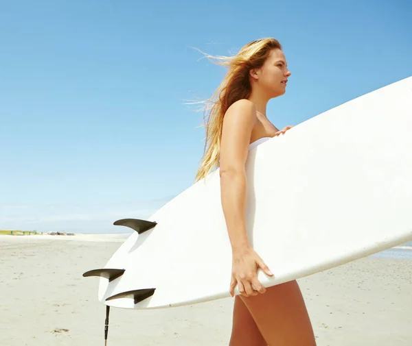 サーフィンの美しさ ビーチでサーフボードを担いでいる若い女性サーファーが — ストック写真