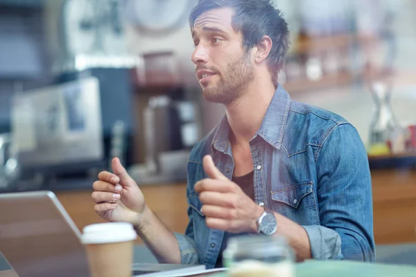 いいぞ 誰かのカメラの前に親指を立ててコーヒーショップに座っている若い男が — ストック写真