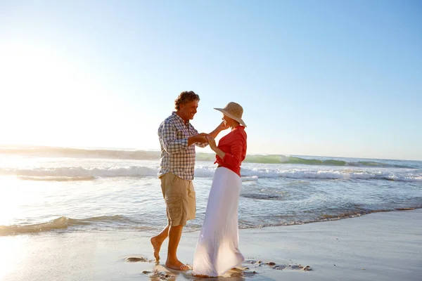 日没に踊ります 成熟した夫婦は午後遅くにビーチを散歩し — ストック写真