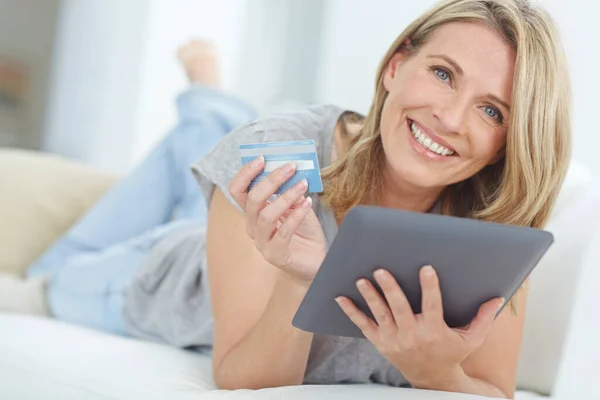 我们有这么多的选择 一个快乐的成熟女人在家里用她的数码平板电脑上网购物的肖像 — 图库照片