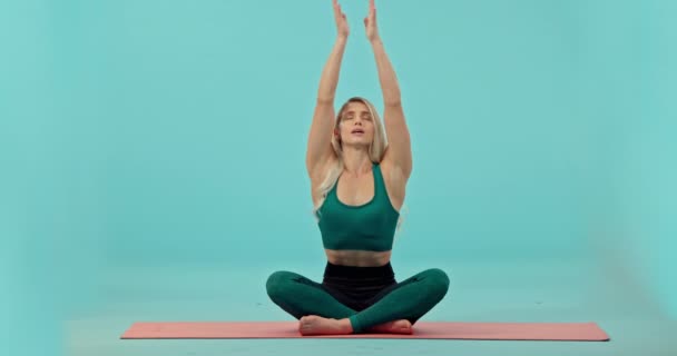 妇女和瑜伽调解在工作室的垫子上 在蓝色背景下进行锻炼或锻炼 快乐女性瑜伽的画像 在地板上冥想精神健康以进行模拟锻炼 — 图库视频影像