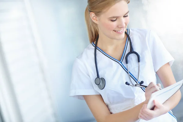 Jovem Médico Diluente Uma Enfermeira Sorrindo Escrevendo Notas Seu Bloco — Fotografia de Stock