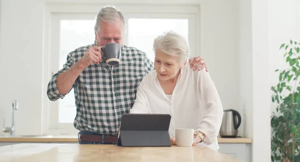 stock image This looks interesting, lets watch. a senior couple looking at something on a digital tablet together