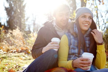Bu an bundan daha mükemmel olamazdı. Şefkatli genç bir çift, açık havada kahve içerken yan yana oturuyorlar.