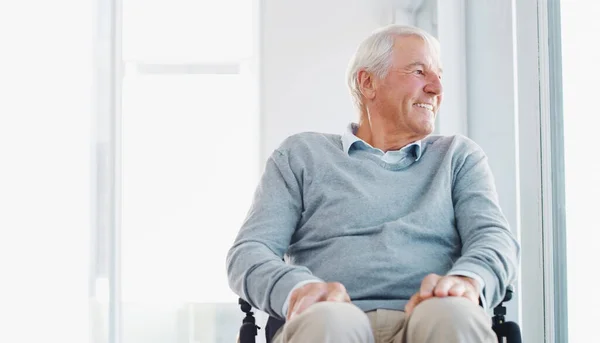 stock image My mobility may be limited but Im happy. a senior man in a wheelchair looking thoughtfully out of a window