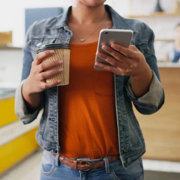 咖啡和连通性很好地结合在一起 一个无法辨认的女人在咖啡店里拿着一杯咖啡时 用手机拍了一张合影 — 图库照片