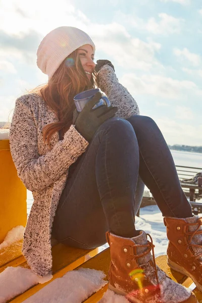 寒冷的日子和温暖的思想 一个漂亮的女人坐在外面雪地里喝着热饮 — 图库照片