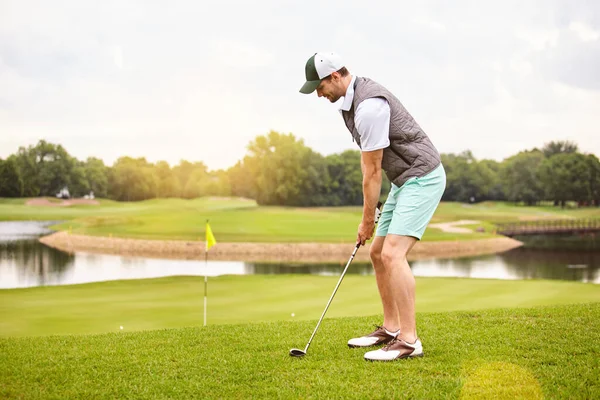 彼のゲームに取り組んでる ゴルフ場でゴルフをしているハンサムな若い男の完全な長さのショット — ストック写真