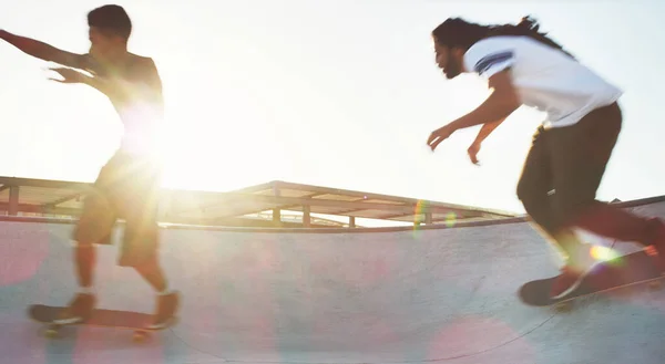 飞奔向夕阳西下两名年轻人在滑板上一起在滑板上滑行的全景镜头 — 图库照片