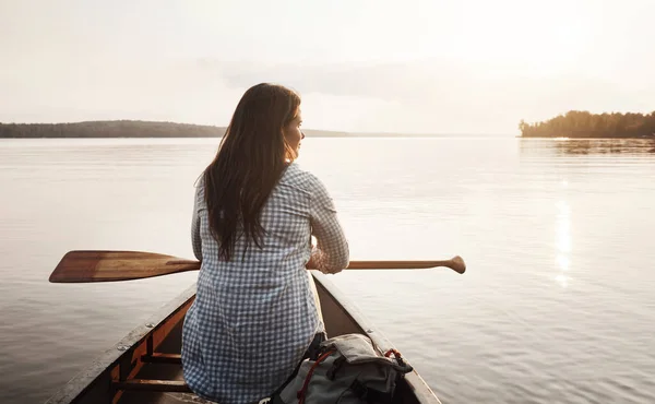 彼女はできるだけいつでも水に乗る 湖でカヌーに乗って楽しむ若い女性のレビューショット — ストック写真