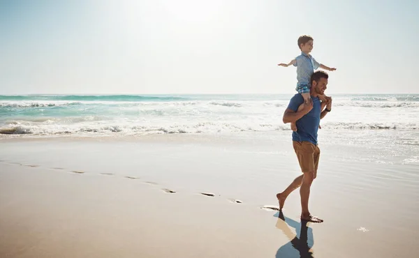 stock image Their trips to the beach are always the best. a father carrying his little son on his shoulders at the beach