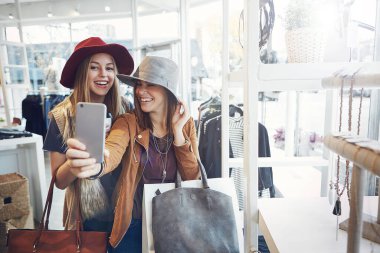 Gülümse. Selfie çekiyorum. İki genç kız arkadaş alışveriş yaparken selfie çekiyorlar.