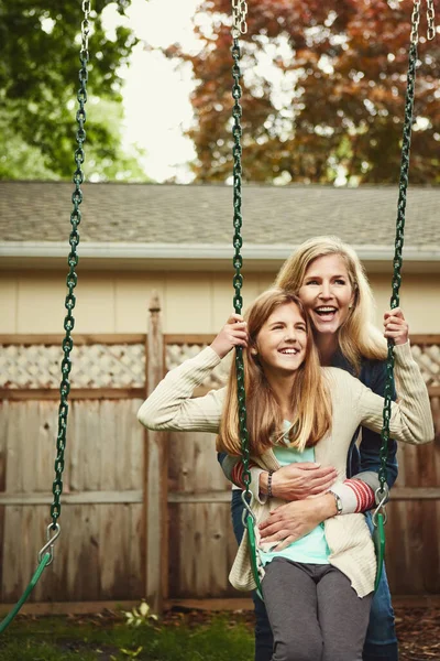因为他们值得你花时间一个母亲和她的女儿在自家后院荡秋千 — 图库照片
