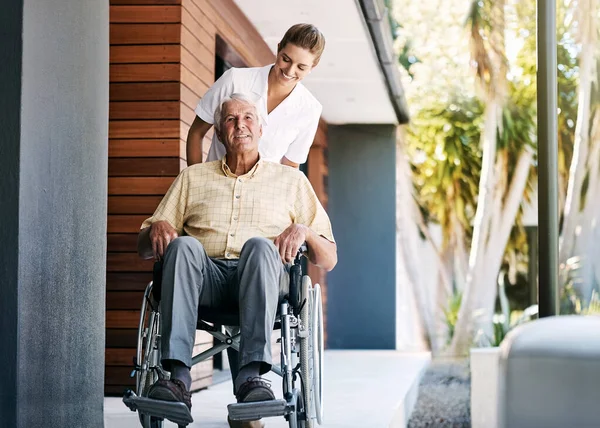 stock image Hes ready to be discharged. a nurse caring for a senior patient in a wheelchair outside a retirement home