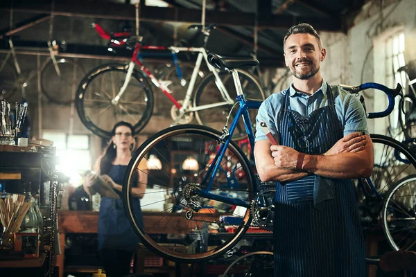 值班的自行车技师 一个成熟男人和他的同事在自行车修理店工作的肖像 — 图库照片