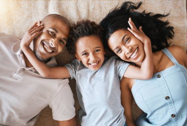 Portre, aile ve üst düzey gülümseme evde, bağlanma ya da birlikte eğlenme. Ebeveynler, mutluluk ve çocuk dinlenme ya da yerde yatma ya da kadın ve erkeklerle halı döşemesi, ilgilenme ya da kaliteli zaman geçirme.