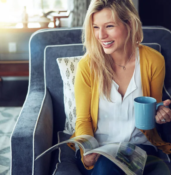 stock image Enjoying my day off. a young woman enjoying a cup of coffee while reading a magazine