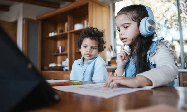 家庭作业和带着耳机的思考 音乐或弟弟坐在家里的办公桌前 学习或与评估 测试或注重教育发展的文件相混淆 — 图库照片