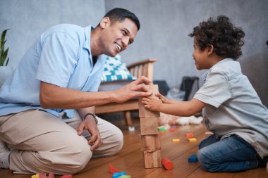 Eğitim, yapı taşları ya da evde oynamak, eğitim oyunları ve öğrenmek için yerde yatan çocuklu mutlu bir baba. Çocuk gelişimi, aile veya baba ve genç çocuk birlikte eğlence dersi, bağ ve aşk için.