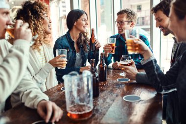 İyi arkadaşlarla güzel bira içeriz. Bir grup arkadaş barda eğleniyor.