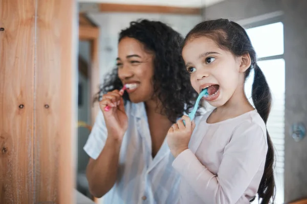 Brushing teeth, child and mom with dental cleaning and learning in a bathroom. Mother, kid and smile of wellbeing and wellness with happiness of health care and toothbrush in the morning at home.