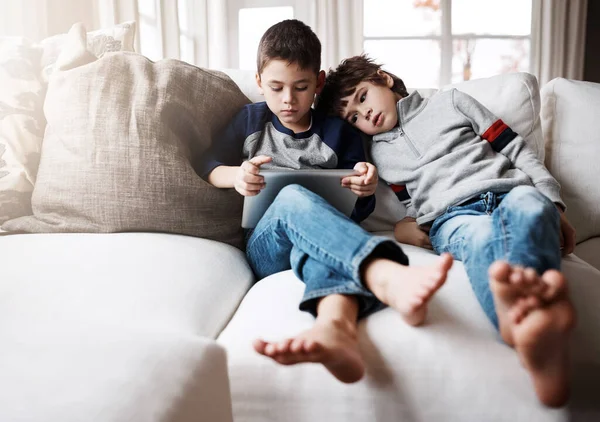 stock image Another day, another fun app to install. two adorable brothers using a digital tablet together while relaxing on the sofa at home