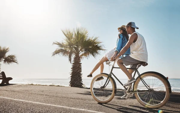 Stock image Summertime is the best weather for adventures. a young couple riding a bicycle together on the promenade