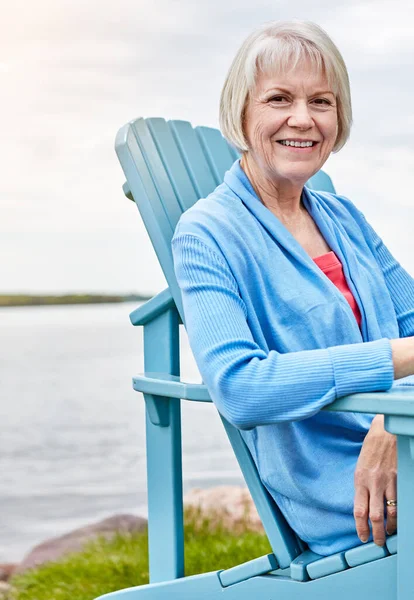 stock image Life begins at retirement. Portrait of a happy senior woman relaxing on a chair outside