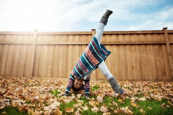 stock image Autumn days demand to be spent outdoors. an adorable little girl doing cartwheels an autumn day outdoors