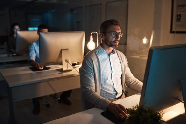 Gece vardiyasında dikkatini topluyor. Yetişkin bir iş adamı geç saatlere kadar ofiste bilgisayar başında çalışıyor.