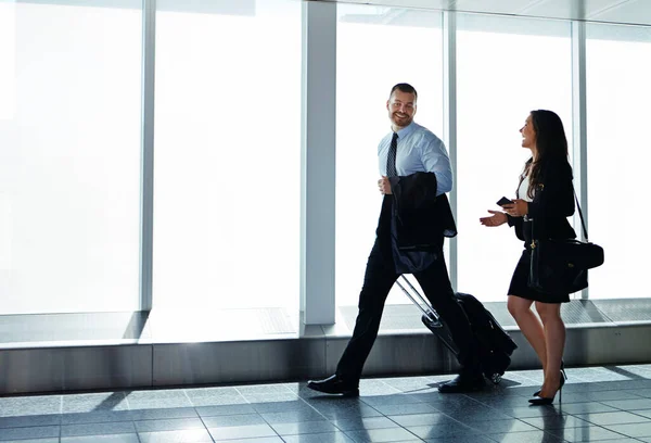 彼らは素晴らしいビジネス旅行仲間を作る 2人のビジネスマンが空港を歩いている間に — ストック写真