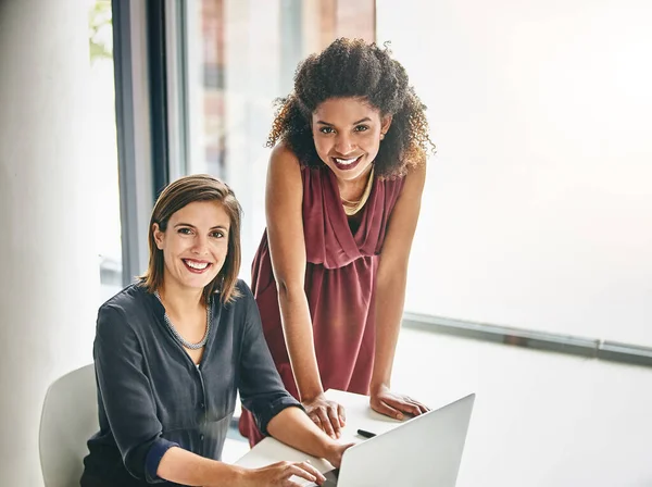 stock image In this office were referred to as the dynamic duo. Portrait of two businesswomen working together on a laptop in an office