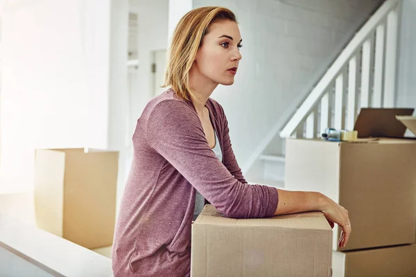 Am I really moving on to better and bigger things. a woman looking thoughtful while moving house