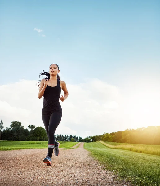 stock image Commit to be fit. a fit young woman out for a run on a beautiful day