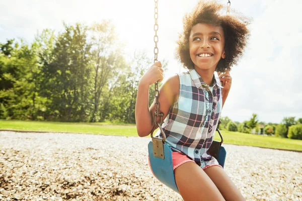 stock image Being young means having nothing but days of fun. a young girl playing on a swing at the park