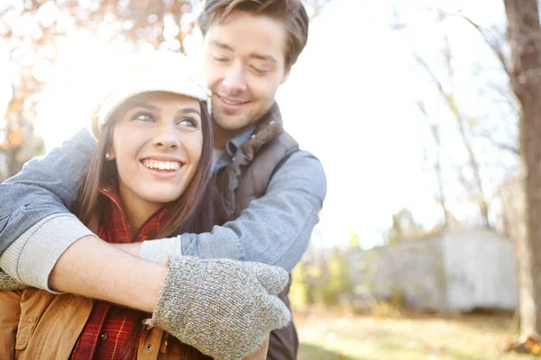 秋天的浪漫一个英俊的年轻人在他的女朋友在大自然中消磨时光时拥抱她 — 图库照片