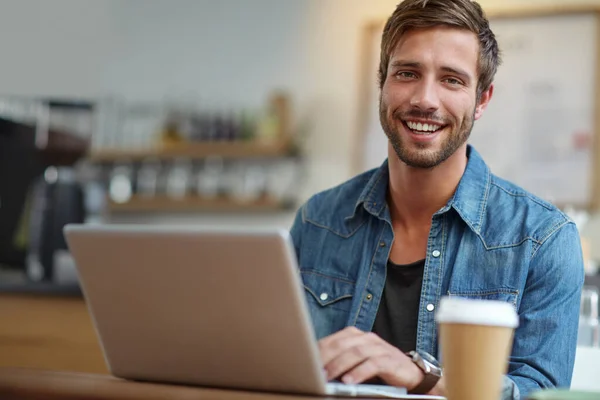 コーヒーと無線Lan時間 コーヒーショップでノートパソコンと座っているハンサムな若い男の肖像画 — ストック写真
